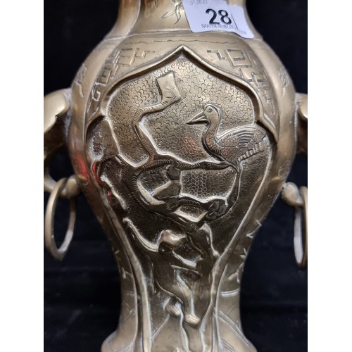 281 - A wonderful heavy solid brass vase boasting elaborate etched foliate motifs and ring handles.