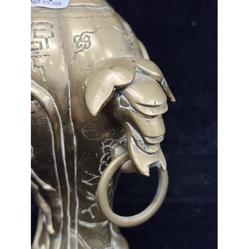 281 - A wonderful heavy solid brass vase boasting elaborate etched foliate motifs and ring handles.