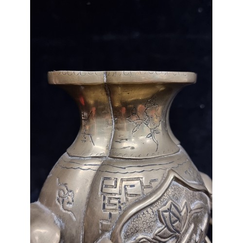 281 - A wonderful heavy solid brass vase boasting elaborate etched foliate motifs and ring handles.