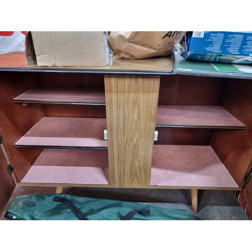 773 - A vintage credenza with three internal shelves concealed by two cupboard doors finished with ornate ... 