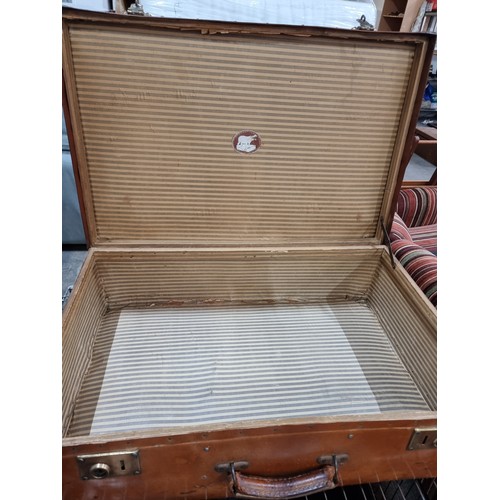 779 - A large vintage leather hard travel trunk with brass hardware and stud reinforcements with carry han... 