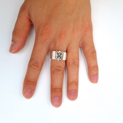 24 - A very unusual cushion cut Moissanite stone ring, set with a thick banded intricately finished mount... 