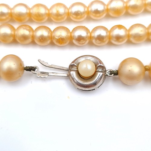 45 - A collection of two stylish faux vintage pearl necklaces, each featuring sterling silver clasps. Dou... 