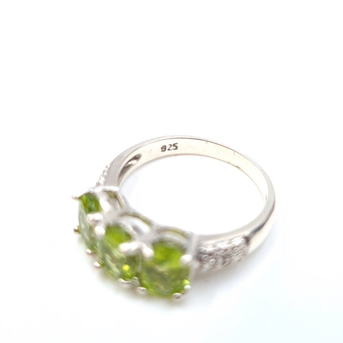 55 - A beautiful three stone gem set ring, featuring a striking stylised mount. Set in sterling silver. R... 