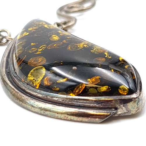 58 - A striking and vivid Baltic Amber sterling silver pendant necklace, featuring Celtic inspired accent... 