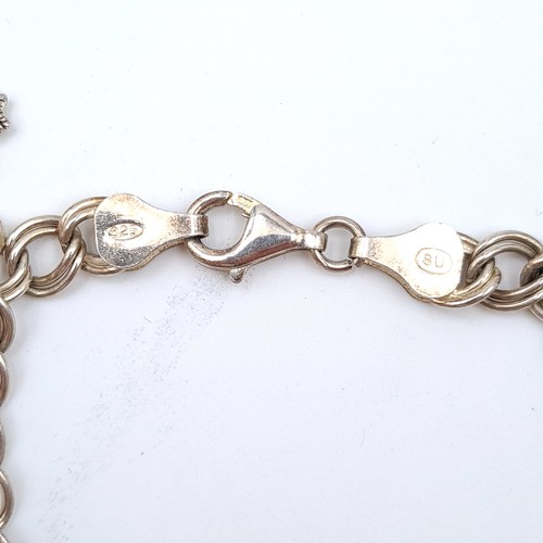 525 - A very high quality example of a eight charm sterling silver bracelet. Weight: 25.10 grams.