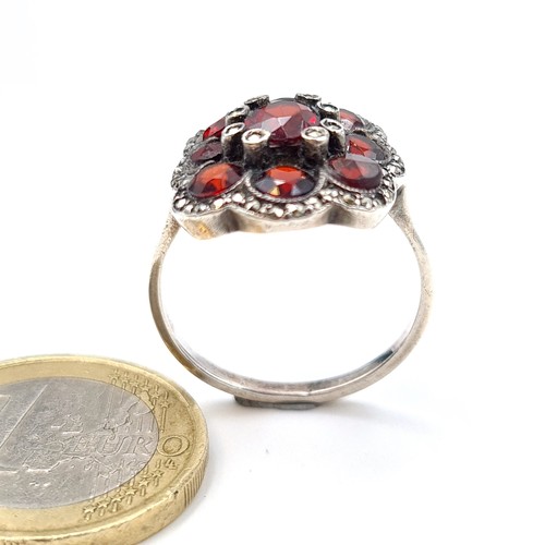 539 - A very attractive 9 stone Garnet floral ring, set with Marcasite setting and surround. Ring size: Q.... 