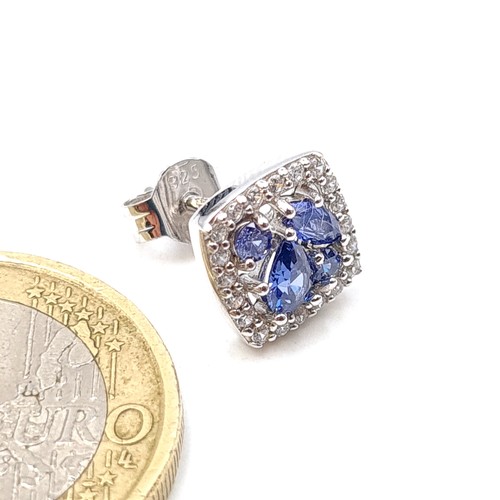 542 - A pair of beautiful Tanzanite stud earrings, set with White Sapphire surrounds. Ring set in sterling... 