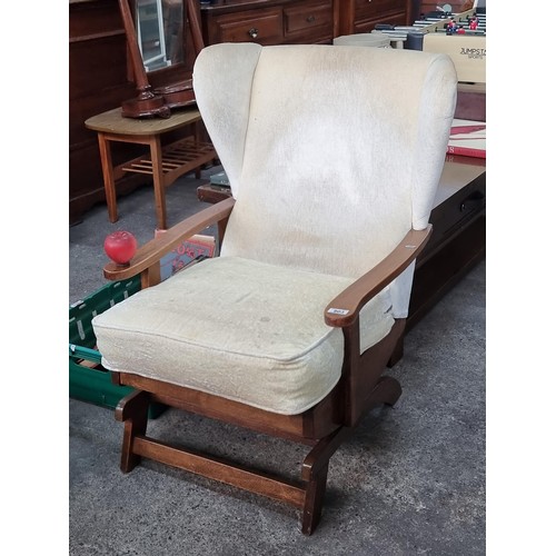 851 - A very comfortable vintage spring loaded rocking chair with high wind back and upholstered in a plus... 