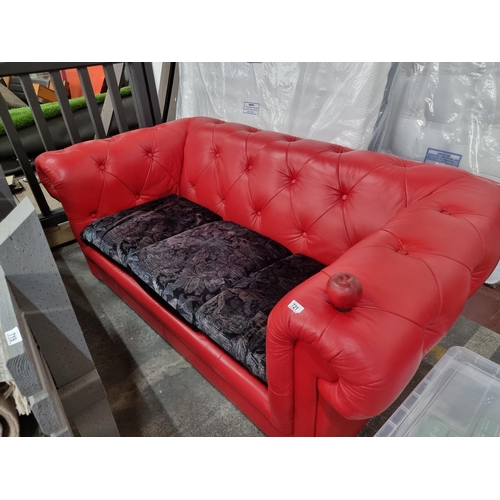 721 - Star Lot : A striking Chesterfield style sofa upholstered in a red button back leather with a trio o... 