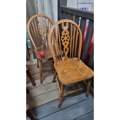 887 - A delightful vintage pair of wheelback chairs with lovely carved and turned wood detailing throughou... 