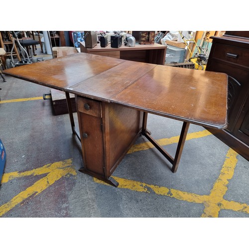 881 - A handsome vintage drop leaf gate leg table with storage compartments in the form of a single drawer... 