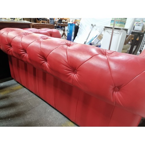 721 - Star Lot : A striking Chesterfield style sofa upholstered in a red button back leather with a trio o... 