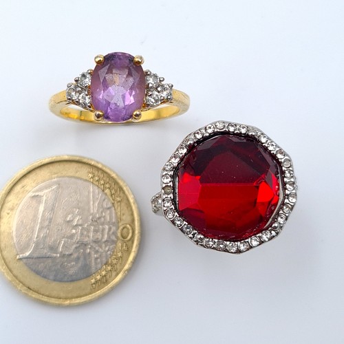 8 - A collection of two attractive cocktail rings, comprising of a facet cut red gem stone example featu... 