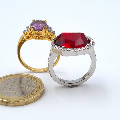 8 - A collection of two attractive cocktail rings, comprising of a facet cut red gem stone example featu... 