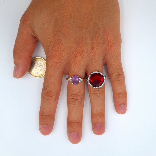 8 - A collection of two attractive cocktail rings, comprising of a facet cut red gem stone example featu... 