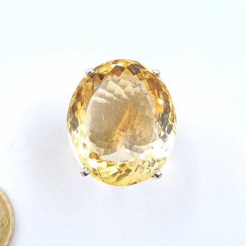 58 - A striking 15 gram natural round cut Citrine cocktail ring, set in sterling silver and featuring a v... 