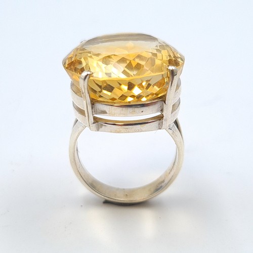 58 - A striking 15 gram natural round cut Citrine cocktail ring, set in sterling silver and featuring a v... 