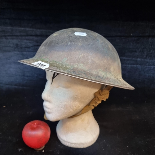 A genuine WWII British brodie helmet with leather interior lining