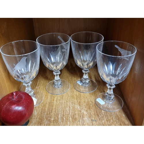 98 - A set of four stemmed wine glasses in an avian theme. Each glass featuring an acid etched bird motif... 