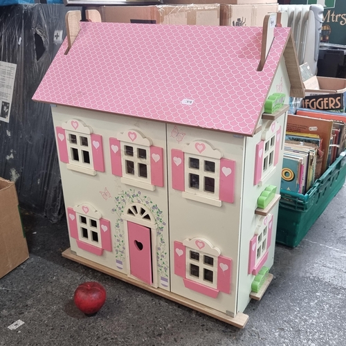 919 - A charming painted wood dollhouse. A very sweet example in a palette of cream and pink. With wooden ... 