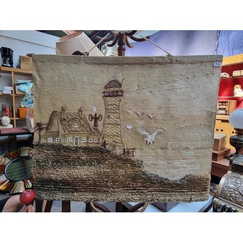 930 - A large atmospheric hand woven wall hanging. This lovely tapestry depicts a cliff side lighthouse wi... 