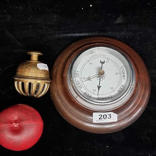 203 - Two vintage items including a heavy Indian brass hand bell and a English made porthole barometer.