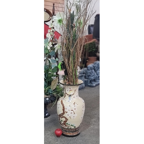 752 - A large Chinese ceramic vase boasting a cherry blossom and songbird motif. With a bouquet of faux fl... 