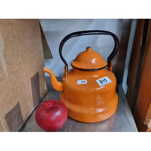 815 - A really striking enamelled metal teapot. Enamelled in a bright shade of orange with black detailing... 