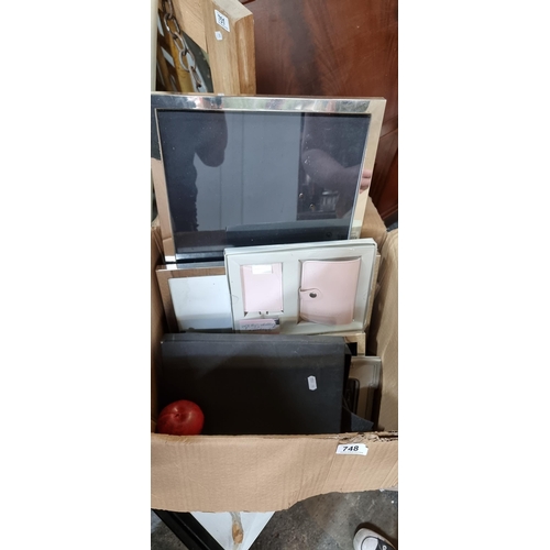 748 - A box containing mixed homeware items including five smart photo frames with a pair in a chrome fini... 