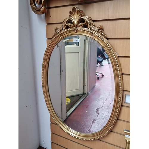 231 - An elegant wall mirror in a Regency style with a bevelled mirror to centre. Housed in a gilt frame w... 