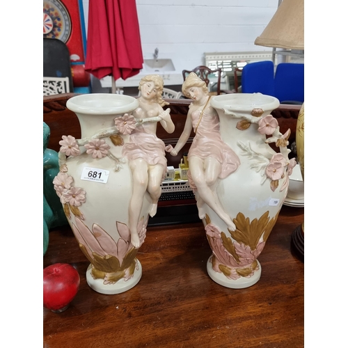 681 - A pair of heavy vintage mantel vases boasting elegant nymph like figures positioned around the neck ... 