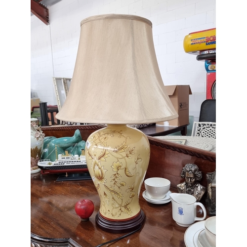 683 - A very large table lamp with ceramic base decorated in a Classical foliate design, topped with a cre... 