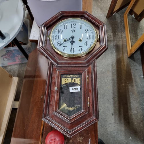 699 - A vintage wall mounting clock with pendulum and eight day winding mechanism. Presented with an impre... 