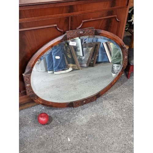 757 - An elegant antique oak arts and crafts mirror. A nice oval example with bevelled antique mirror plat... 