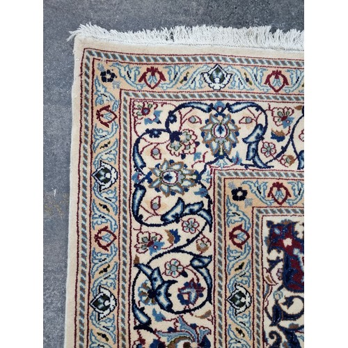 674 - Star Lot : A very large Persian handmade, hand knotted rug in shades of beige, cream, navy and green... 