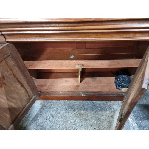 696 - An elegant victorian mahogany sideboard with shelved cupboard storage to base. Featuring nice relief... 