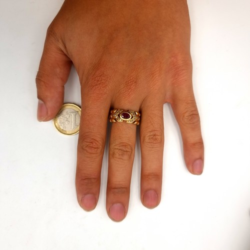 1 - A beautiful unmarked gold ring, set with a central Ruby stone setting and held with a sparkling gem ... 