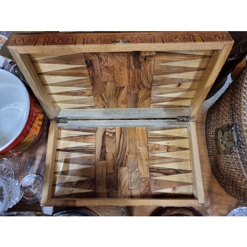 166 - An ornately carved wooden folding chess and backgammon board. (no pieces)