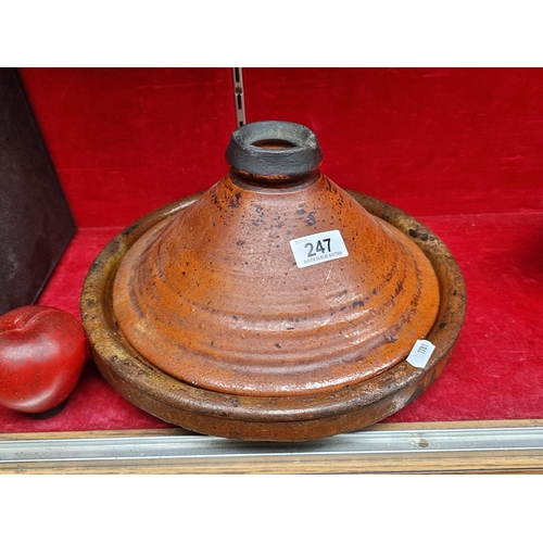 247 - A heavy quality vintage Moroccan tagine clay pot comprising of a lid and base in a deep orange glaze... 