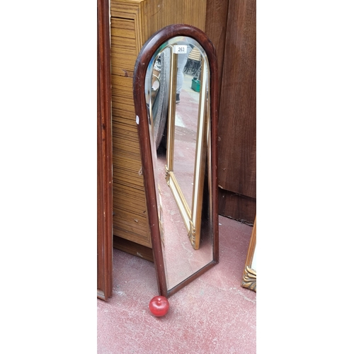 263 - A heavy vintage bevelled wall mirror with an arch top and held in a wooden frame. With bracket fitti... 