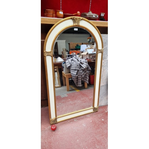 264 - Star Lot : A large arch top wall mirror with bevelled glass and held in a Neoclassical style frame w... 