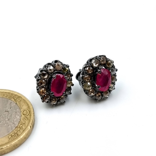 49 - An unusual pair of Ruby and Diamond floral earrings, featuring an intricate cluster setting and butt... 