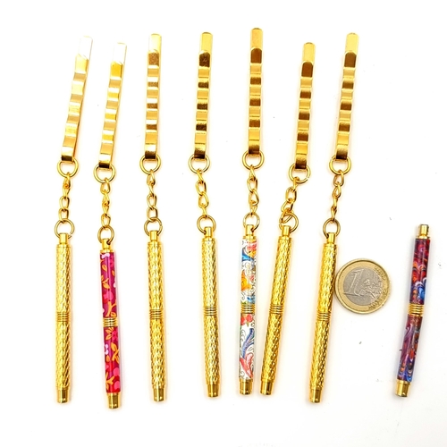 881 - An assorted collection of clip on miniature ball point pens, five of which are set in a gold toned f... 