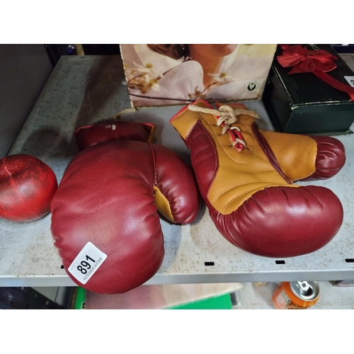 891 - A pair of retro leather 6 ounce boxing gloves with laces for tightening. In a burgundy and yellow fi... 