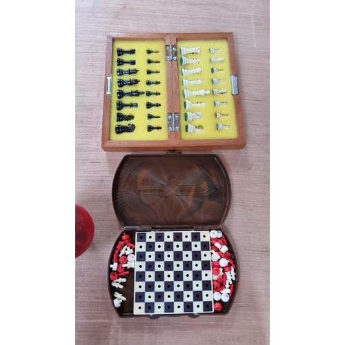 914 - Two miniature travel chess sets including an example with pattern to exterior and with all pieces in... 