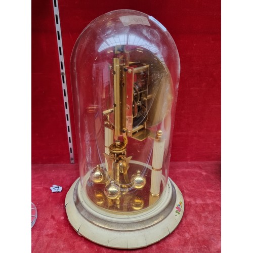 804 - A German made vintage Kern & Sohne dome clock with a rotating pendulum, highly ornate floral motifs,... 