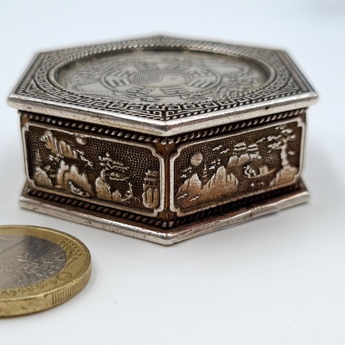 12 - A Chinese hexagonal pill box, set with profuse inlayed coins to face and reverse and featuring fabul... 