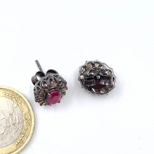 49 - An unusual pair of Ruby and Diamond floral earrings, featuring an intricate cluster setting and butt... 