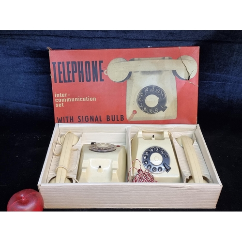 A fabulous vintage double telephone set. Housed as old new stock in original red and yellow box. Includes a pair of cream coloured rotary telephones. Requires four U-2 batteries.